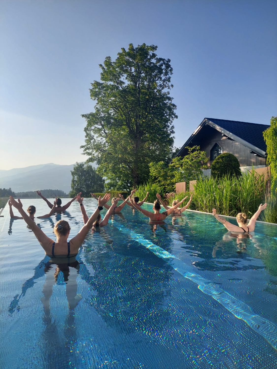 Neun Frauen machen Sport im Infinity Pool.