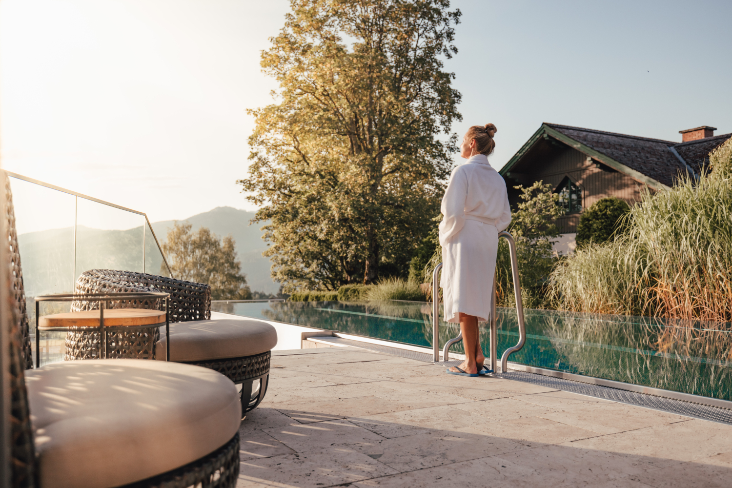 Frau im Bademantel stehend vor dem Infinity Pool des Hotels Annelies