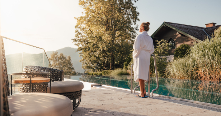 Infinity Pool des Hotels Annelies Frau im Bademantel stehend vor dem Infinity Pool des Hotels Annelies