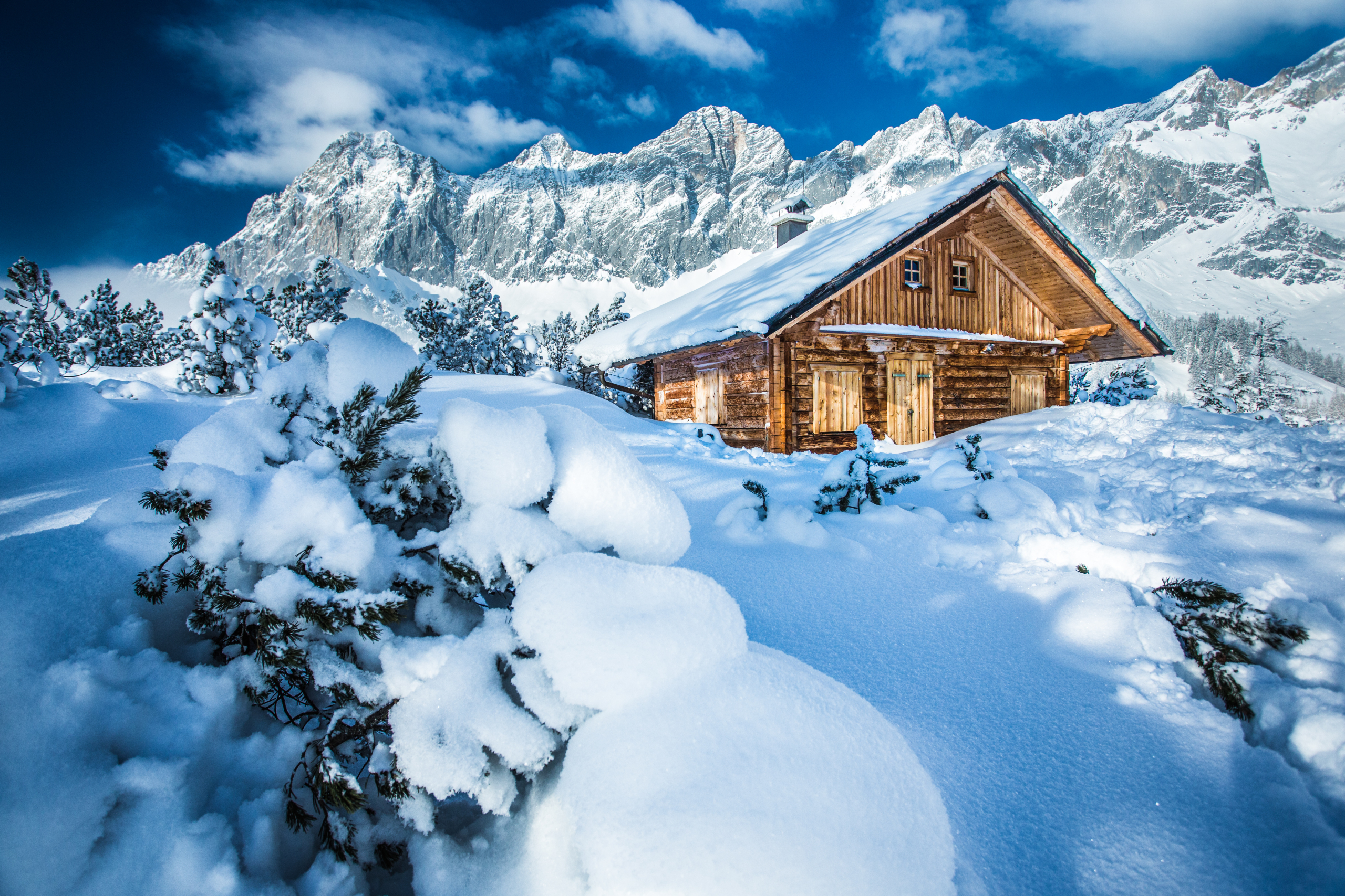 Winterlandschaft rund um den Neustattalem und dem Dachsteinmassi Eine Holzhütte eingebettet in eine Winterlandschaft - tiefer Schnee, schneebedeckte Bäume und Berge
